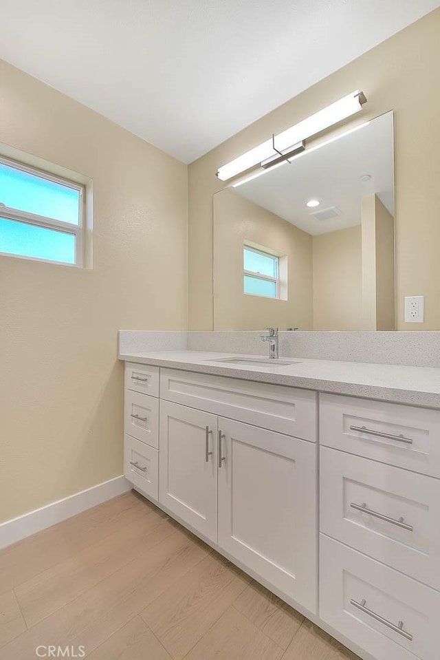 bathroom with wood-type flooring, vanity, and plenty of natural light