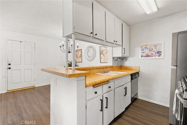 kitchen with dark wood-type flooring, sink, white cabinets, and stainless steel appliances