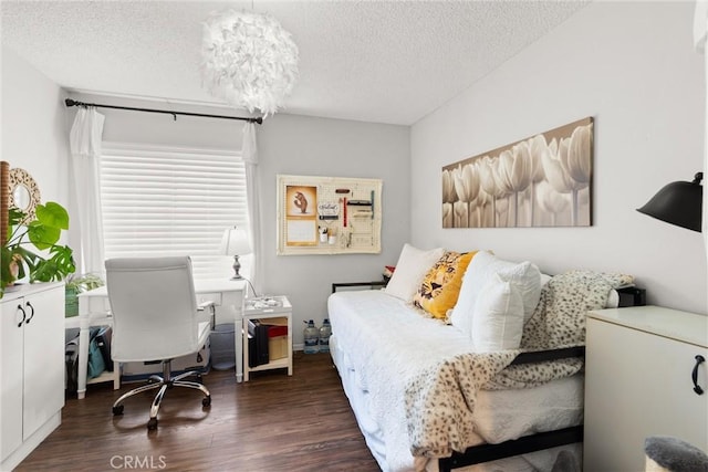 bedroom with a textured ceiling and dark hardwood / wood-style floors