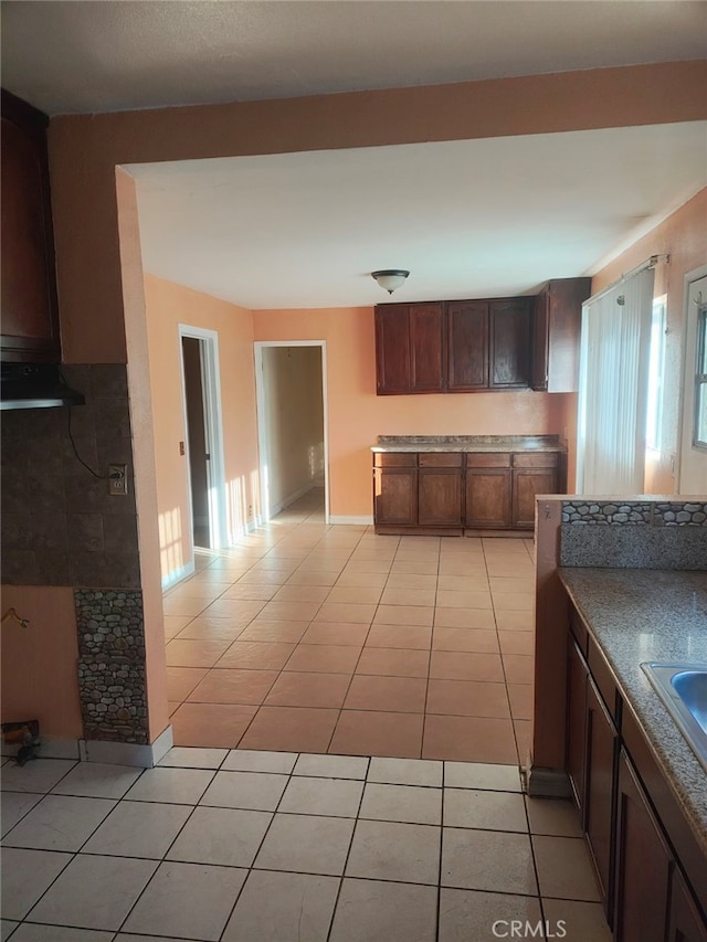 kitchen featuring dark brown cabinets and light tile patterned flooring