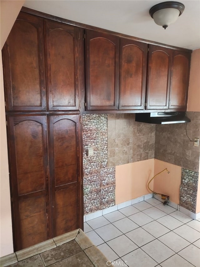 kitchen with dark brown cabinets, backsplash, and light tile patterned flooring