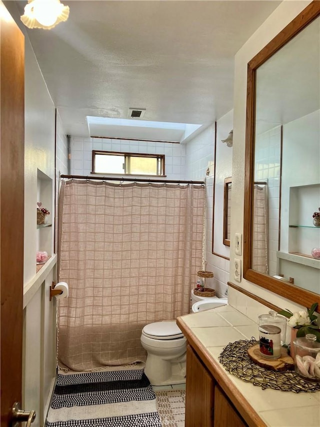 bathroom featuring a shower with curtain, tile patterned flooring, vanity, and toilet