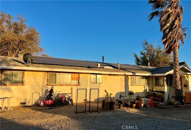 back of property featuring solar panels