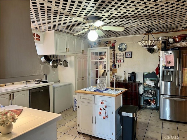 kitchen featuring stainless steel fridge, white cabinetry, tile counters, and ceiling fan