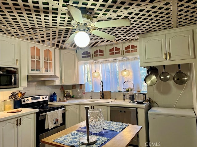 kitchen with plenty of natural light, decorative light fixtures, sink, and appliances with stainless steel finishes