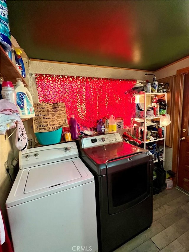 laundry room with wood-type flooring and independent washer and dryer