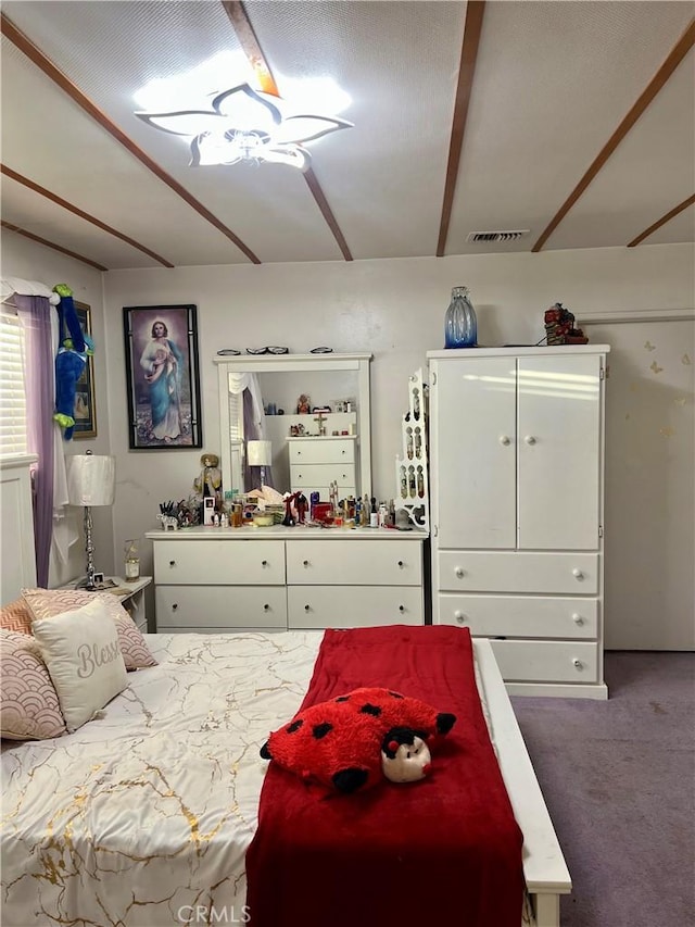 bedroom featuring carpet and beamed ceiling