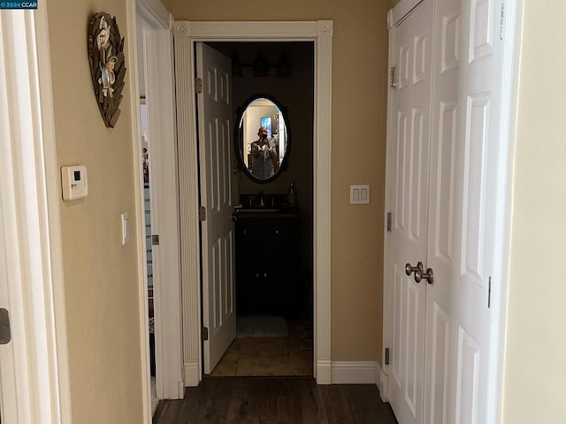 corridor with dark wood-type flooring and sink