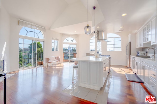 kitchen with white cabinetry, sink, a kitchen island, and light hardwood / wood-style floors