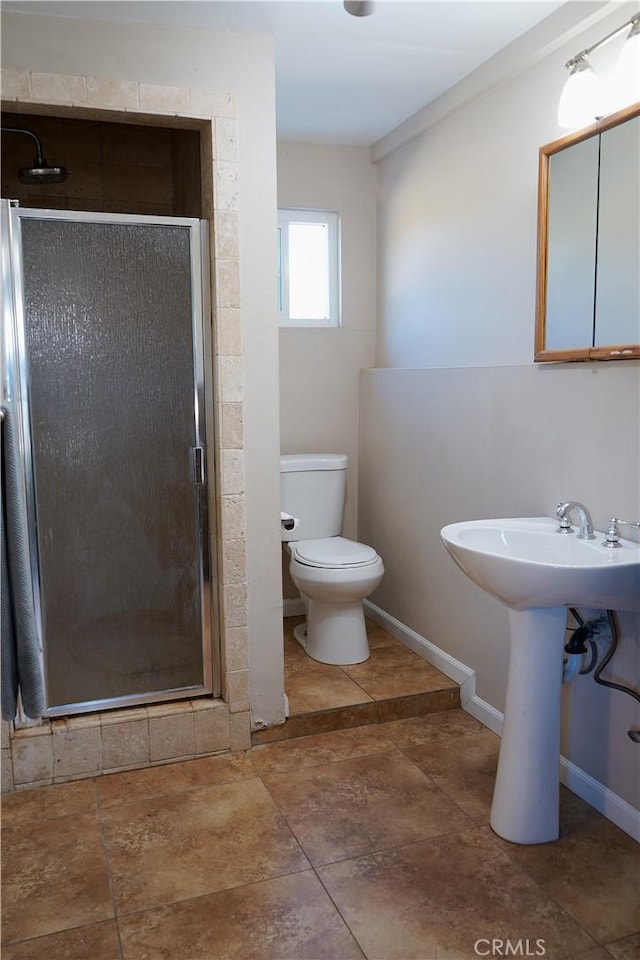 bathroom featuring toilet, an enclosed shower, and sink