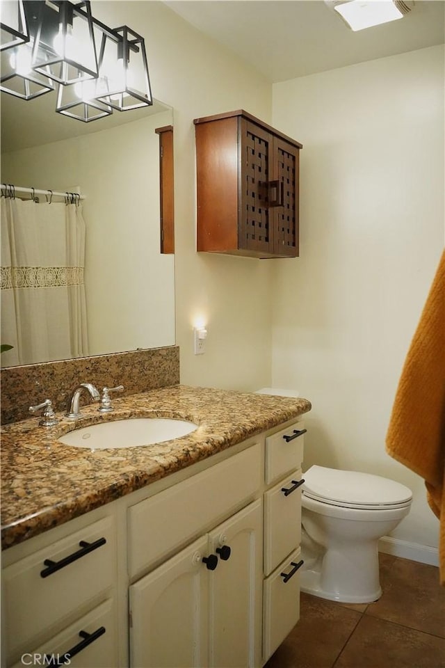 bathroom with toilet, vanity, tile patterned floors, and a chandelier