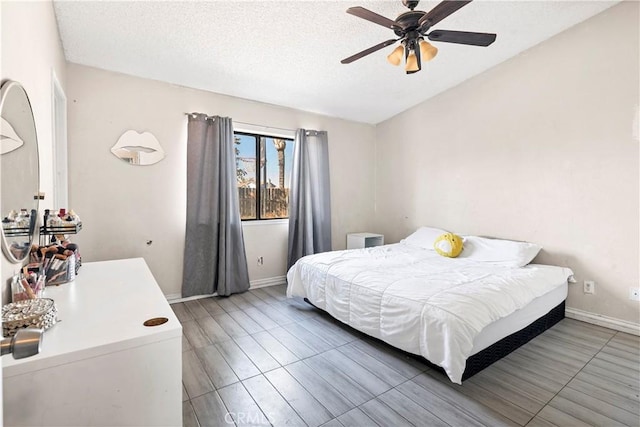 bedroom with lofted ceiling, ceiling fan, dark wood-type flooring, and a textured ceiling