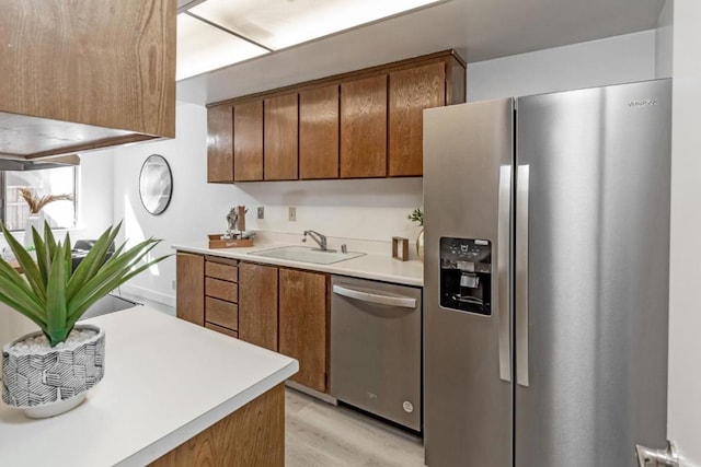 kitchen with light hardwood / wood-style floors, sink, and stainless steel appliances