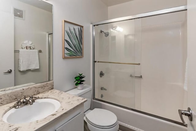 full bathroom featuring combined bath / shower with glass door, vanity, and toilet