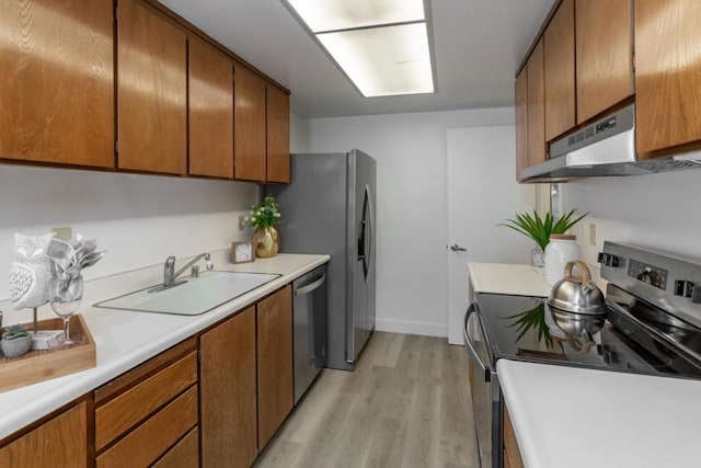 kitchen with sink, stainless steel appliances, light wood-type flooring, and ventilation hood