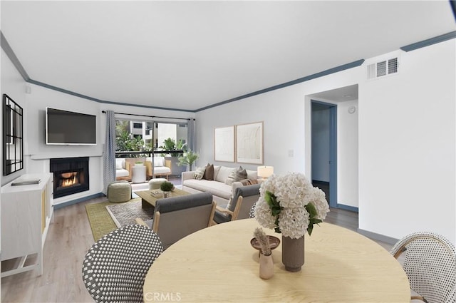 dining room featuring wood-type flooring and crown molding