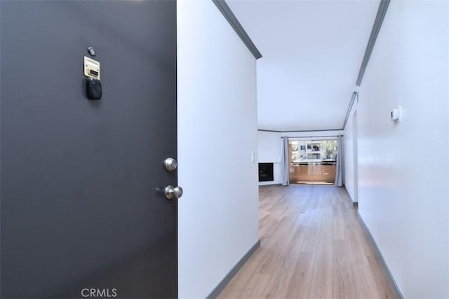 hall with crown molding and light hardwood / wood-style floors