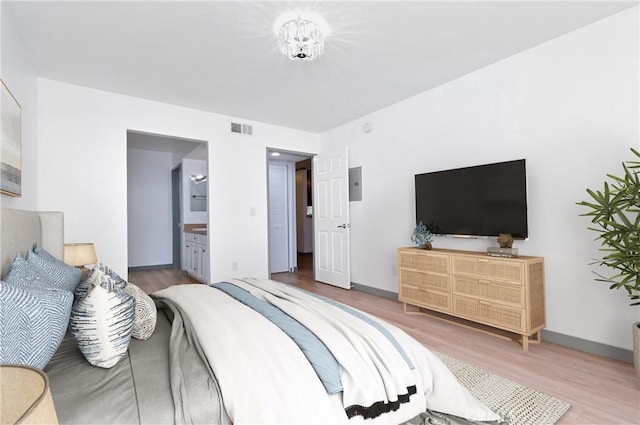 bedroom with wood-type flooring and ensuite bath