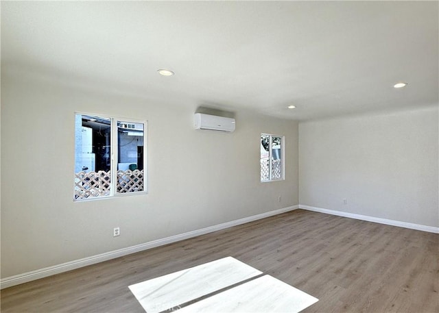 spare room featuring light wood-type flooring and a wall mounted AC