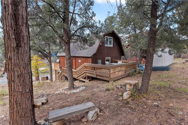 rear view of house with a deck and a storage shed