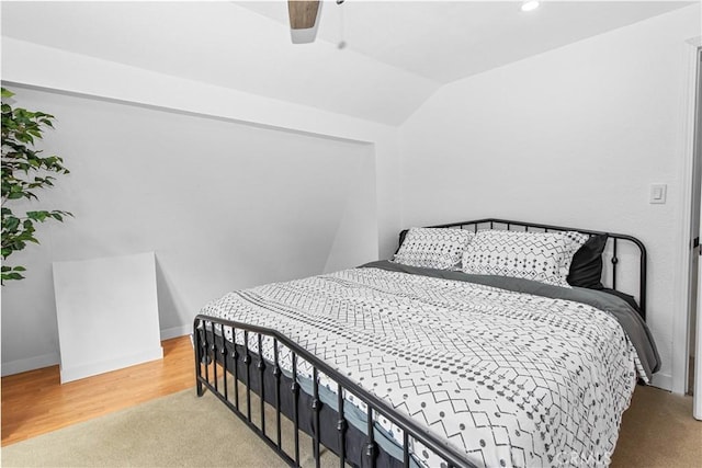 bedroom with ceiling fan, wood-type flooring, and lofted ceiling