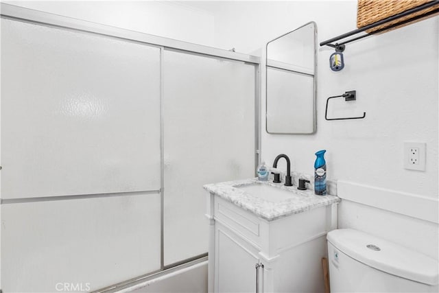 full bathroom featuring toilet, vanity, and combined bath / shower with glass door