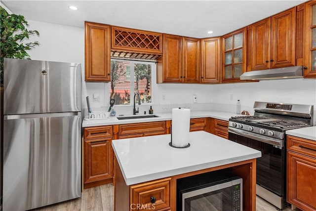 kitchen featuring a center island, stainless steel appliances, light hardwood / wood-style floors, and sink