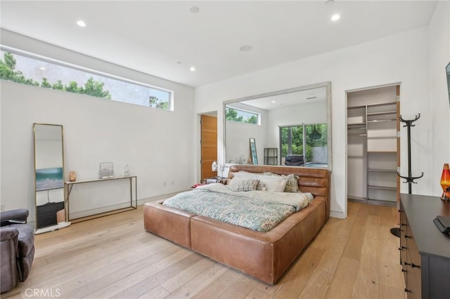 bedroom with a spacious closet, a closet, and light wood-type flooring