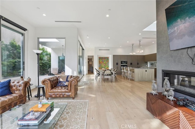 living room with light hardwood / wood-style flooring and a large fireplace