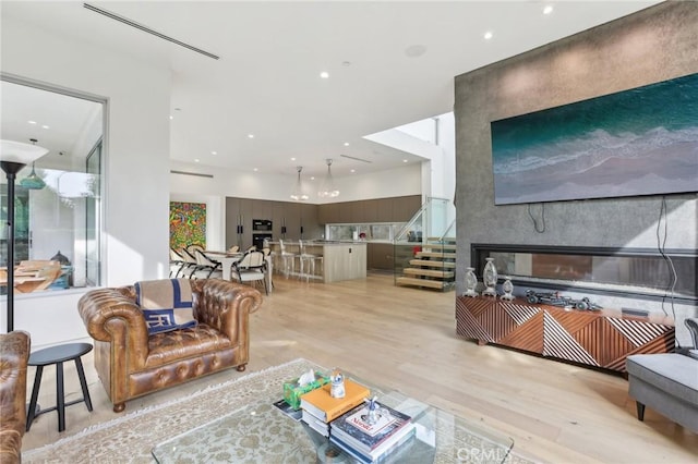 living room with a large fireplace and light hardwood / wood-style flooring