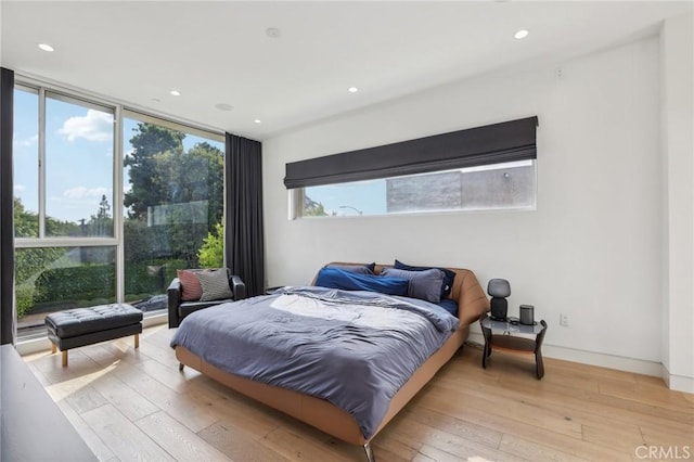 bedroom featuring multiple windows and light hardwood / wood-style flooring