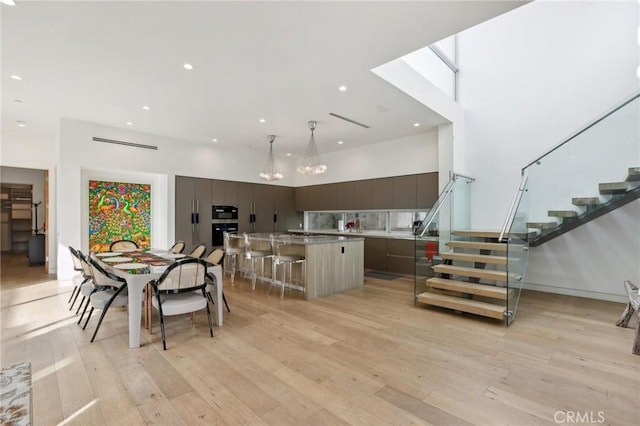 dining area featuring light hardwood / wood-style flooring and a high ceiling