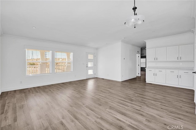 unfurnished living room with light hardwood / wood-style floors and crown molding