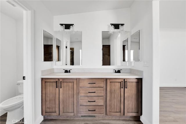 bathroom with vanity, wood-type flooring, lofted ceiling, and toilet