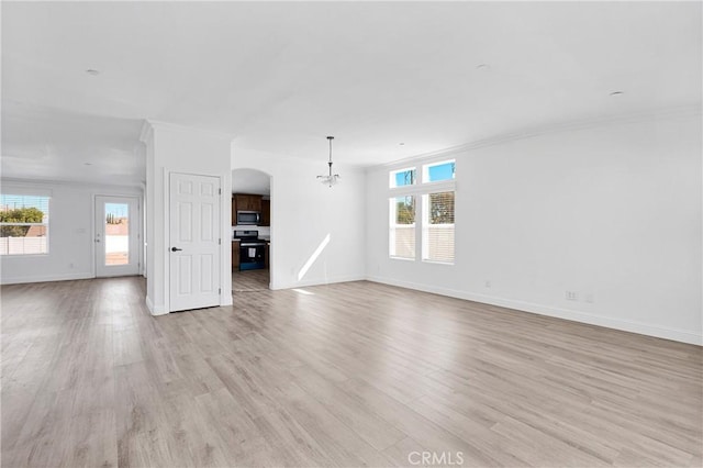 unfurnished living room featuring plenty of natural light, light wood-type flooring, and crown molding