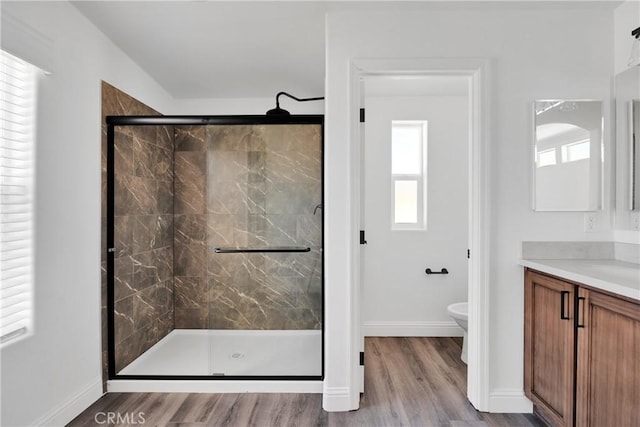 bathroom featuring hardwood / wood-style floors, vanity, toilet, and walk in shower