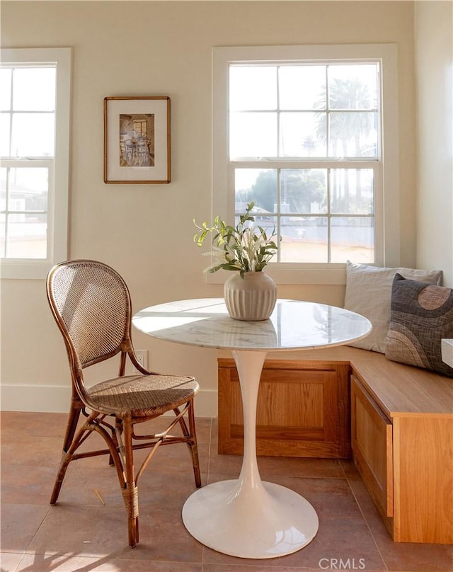 dining space with light tile patterned floors, breakfast area, and plenty of natural light