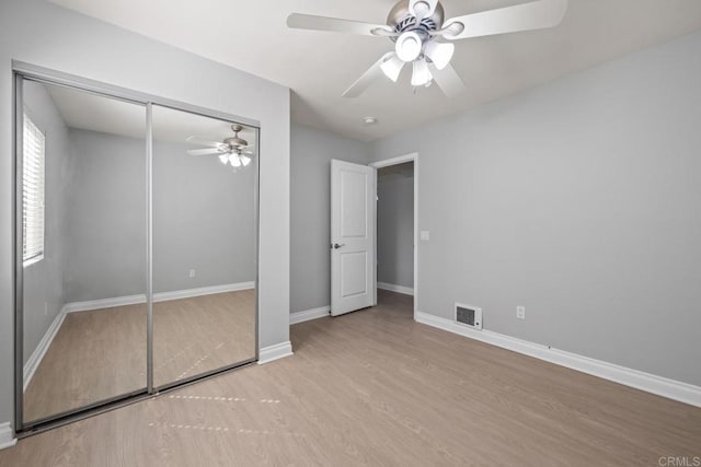 unfurnished bedroom with a ceiling fan, visible vents, baseboards, a closet, and light wood finished floors