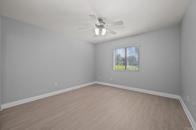 unfurnished room with a ceiling fan, light wood-style flooring, and baseboards