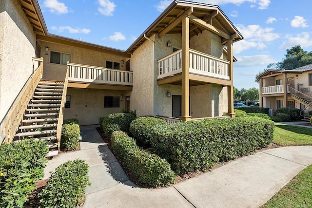 exterior space with stairway and stucco siding