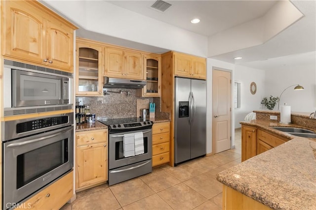 kitchen featuring decorative backsplash, appliances with stainless steel finishes, light tile patterned floors, and light brown cabinetry