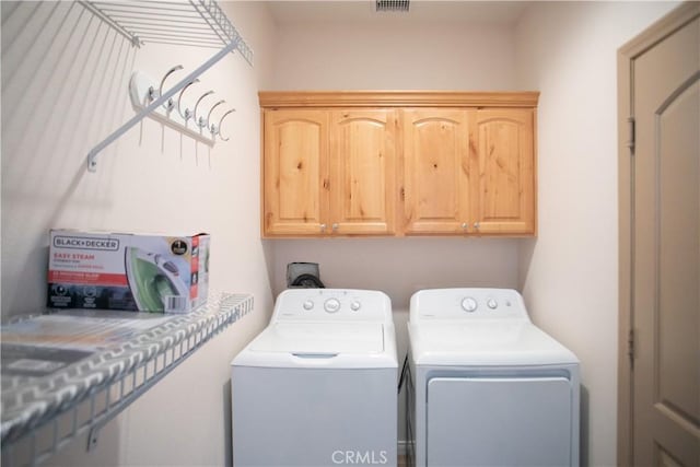 laundry room with cabinets and washer and dryer