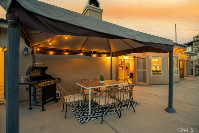 patio terrace at dusk featuring a gazebo