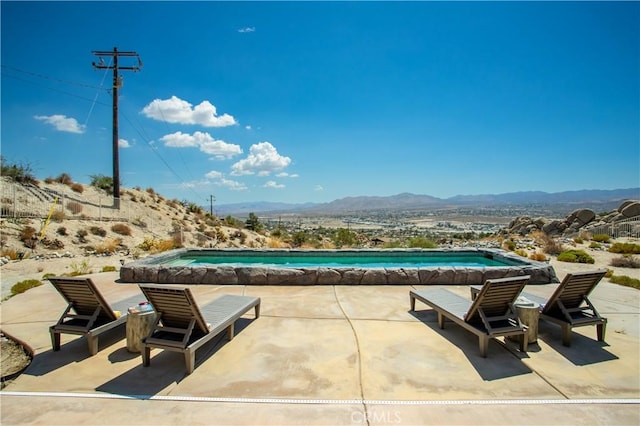 view of swimming pool with a patio area and a mountain view