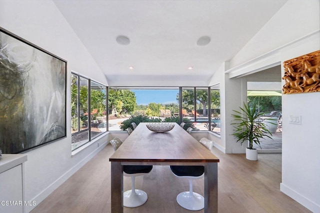 dining space featuring light hardwood / wood-style floors and vaulted ceiling