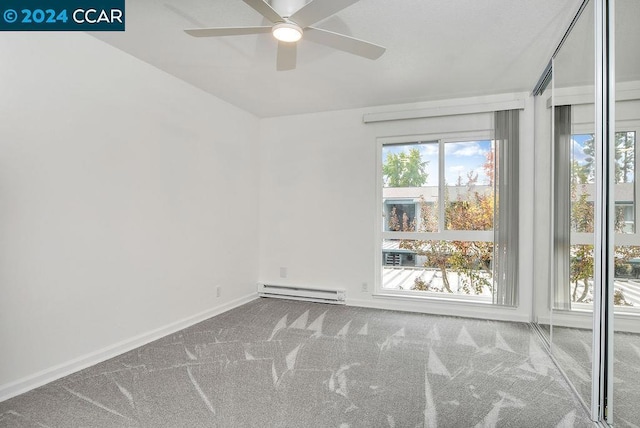 carpeted spare room with a baseboard heating unit and ceiling fan