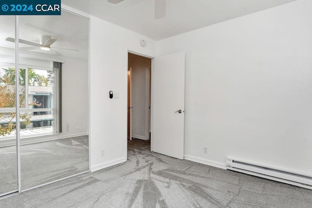 carpeted empty room with a baseboard radiator and ceiling fan