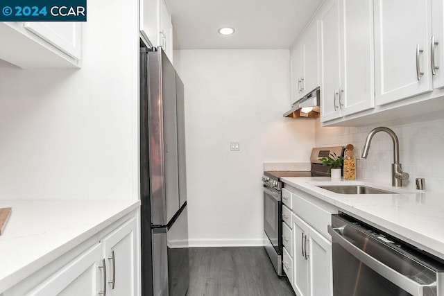 kitchen featuring sink, appliances with stainless steel finishes, light stone counters, white cabinets, and dark hardwood / wood-style flooring