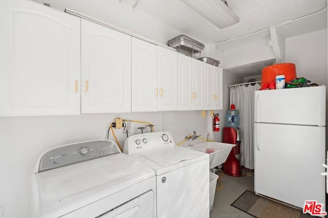 washroom featuring cabinets, sink, and washing machine and clothes dryer