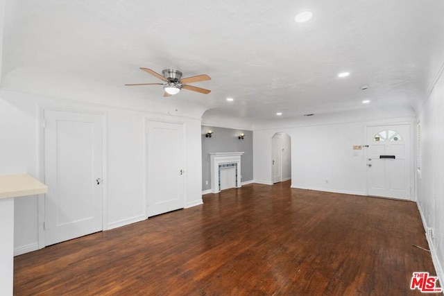 unfurnished living room featuring ceiling fan and dark hardwood / wood-style flooring